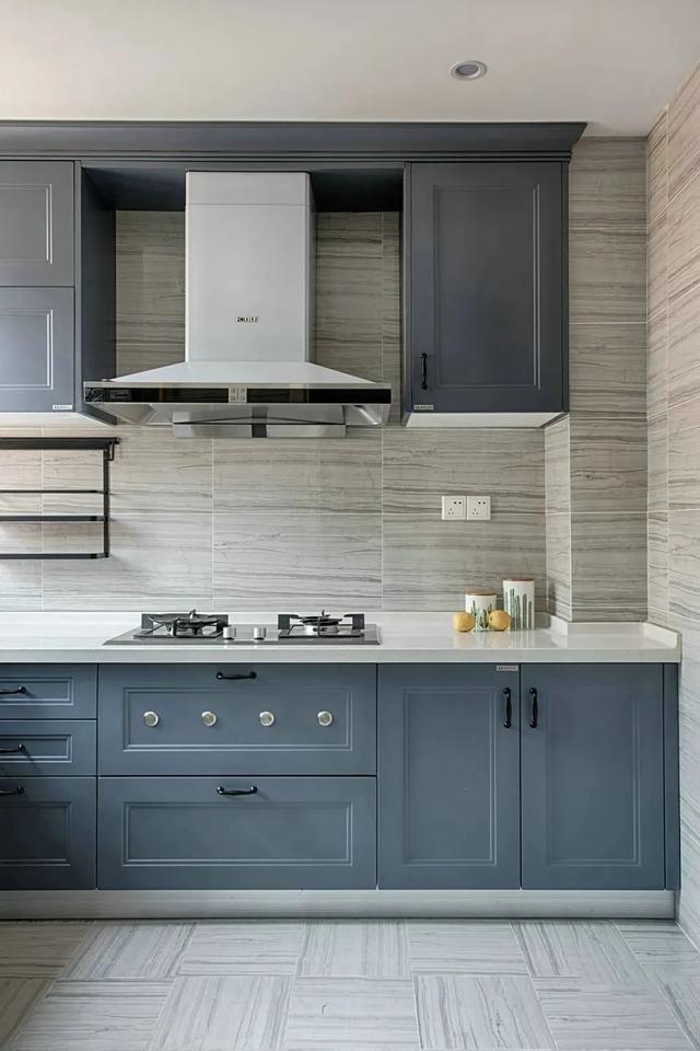 厨房在独特的墙面地砖基础,装上深蓝色的橱柜,让做饭的空间也干净